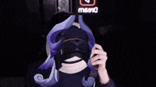 a person with a mask on their face in front of a sign that says ' mbc '