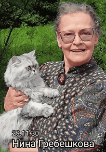 a woman with glasses is holding a cat with the date 29.11.30
