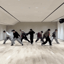 a group of young men are dancing together in a large room