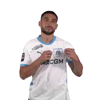 a man wearing a maccgm jersey holds up a badge