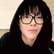 a close up of a person wearing glasses and a hoodie that says supreme