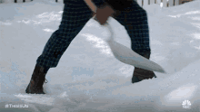 a person is shoveling snow with a shovel in a yard .