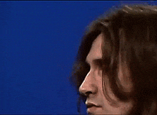 a close up of a person 's face with blue background