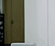 a chair is sitting in front of a white wall in a room