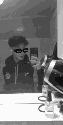 a young man is taking a selfie in front of a mirror .