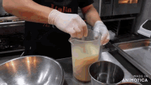 a man wearing gloves is pouring liquid into a measuring cup with the words made in animatica on the bottom