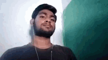 a man with a beard wearing headphones and a black shirt .