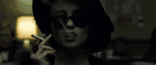 a woman smoking a cigarette in a dark room