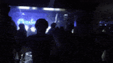 a crowd of people standing in a dark room