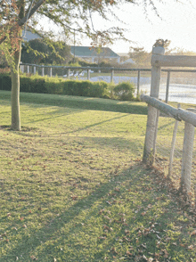 a wooden fence is surrounded by a lush green lawn