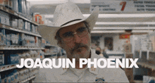 a man with a cowboy hat and glasses is named joaquin phoenix