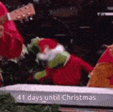 a person is playing a guitar in front of a christmas tree with the words 41 days until christmas on the bottom .