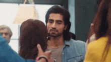 a man and a woman are standing next to each other in a crowded room .