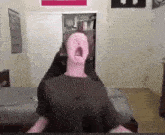 a person with their mouth open in a room with a sign that says ' i love you ' on it