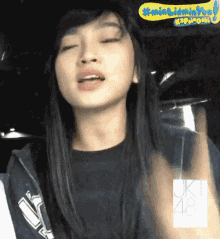 a girl with long hair is wearing a black shirt with jk48 on it