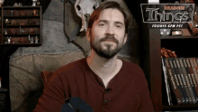a man sitting in front of a sign that says dragons things