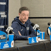 a man sits at a table with a sign that says kaday richmond on it