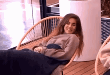a woman is sitting in a chair with a blanket on her lap .