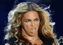 a close up of a woman 's face with her mouth open