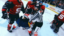 a hockey player with the number 5 on his jersey is being surrounded by other players