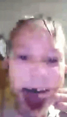 a close up of a baby 's face with a purple background and a tongue sticking out .