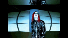a woman with red hair is wearing sunglasses and a black coat