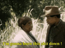 a man and a woman are standing next to each other and the woman is saying i 'm gonna burn this shit down