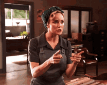 a woman wearing a headband and overalls points at something
