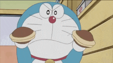 a cartoon character named doraemon is holding two pancakes