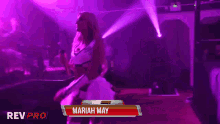 a woman in a white dress is standing in front of a rev pro sign