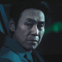 a close up of a man 's face with a green background