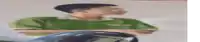 a blurry picture of a man in a green shirt sitting on a motorcycle .