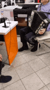 a man playing an accordion in a store with a sticker that says ' a ' on it