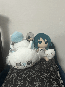 three stuffed animals are laying on a bed including a stuffed cat