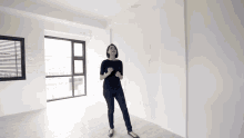 a woman stands in an empty room with a window that says paradise