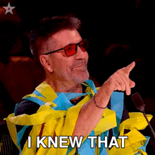 a man wearing sunglasses is pointing at something with the words " i knew that " above him