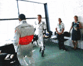a man in a mercedes racing suit talks to a woman