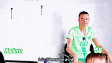 a woman in a green shirt is sitting in a chair and talking to someone .