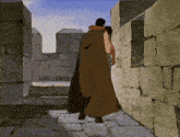a man in a long brown cape is walking down a stone walkway
