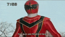 a red power ranger is standing in front of trees and says you guys are finished here