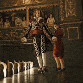 a man and a woman in costume are walking in front of a crowd