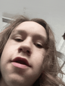 a person with long hair is making a funny face