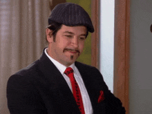 a man in a suit and tie with a mustache is wearing a hat