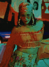 a woman wearing a crop top and a bandana is standing in a dark room .