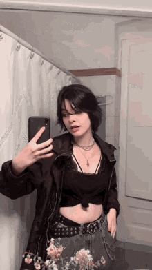 a woman taking a picture of herself in the mirror