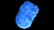 a blue rock is surrounded by purple and white stars