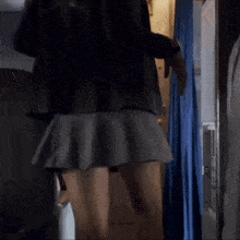 a woman in a short skirt is standing in a room