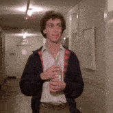 a man in a plaid jacket is holding a bottle of alcohol