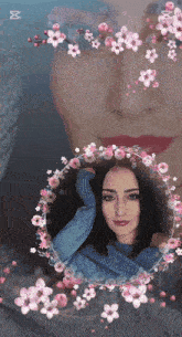 a woman in a blue sweater is surrounded by flowers