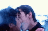 a couple of men kissing each other in the rain .